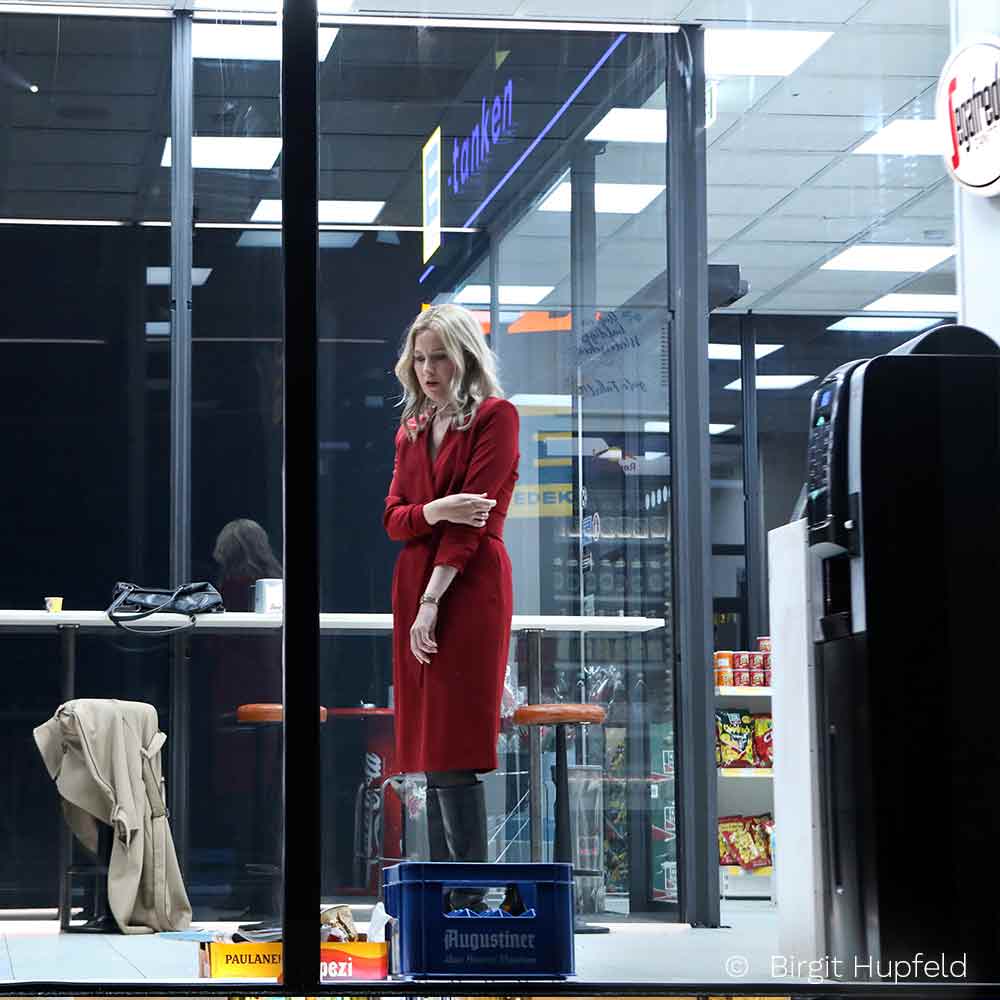 Frau im roten Kleid in einem Glasgebäude
