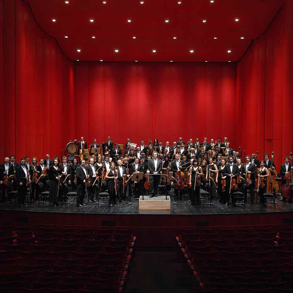 Orchester auf einer Bühne mit roten Wänden