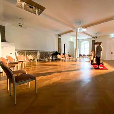 Ein großer Raum mit Holzboden und Stühlen
