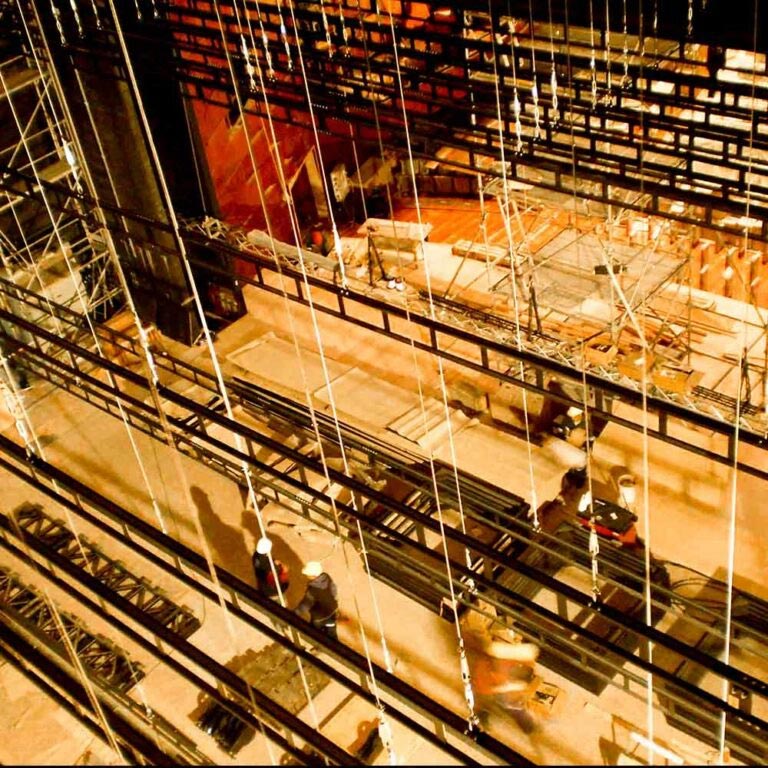 Eine Bühne von oben mit baulichen Elementen und Arbeitern in einem Theater.