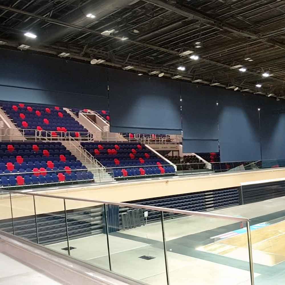 Eine leere Sportarena mit blauen und roten Sitzen in symmetrischen Mustern